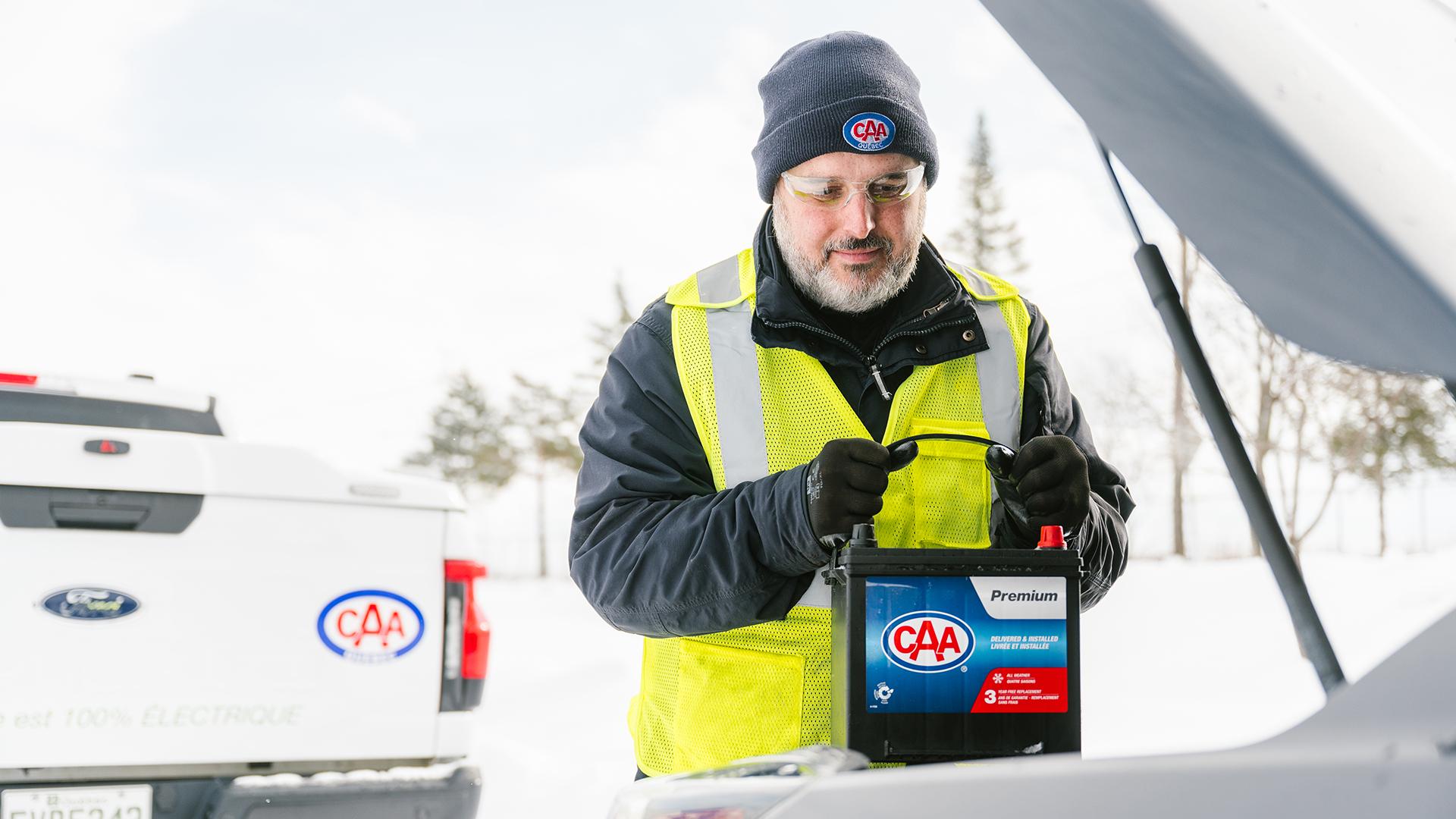 Un patrouilleur d’Assistance batterie installe une batterie CAA dans le véhicule d'un membre.
