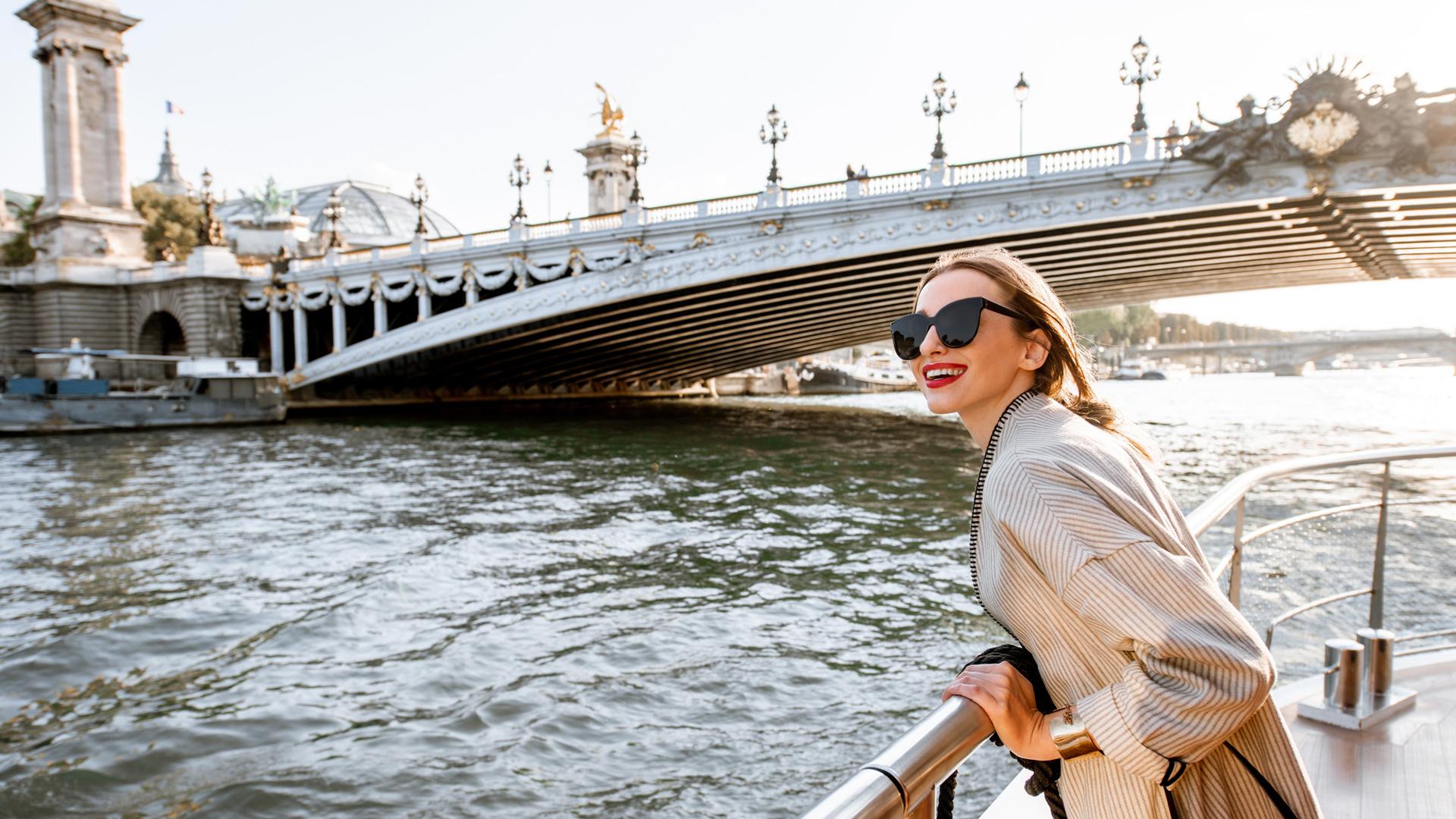 En croisière fluviale, une femme profite de la vue sur le pont alors que son navire circule sur l’eau.